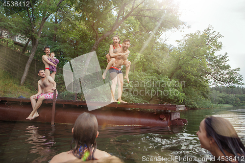 Image of Enjoying river party with friends. Group of beautiful happy young people at the river together