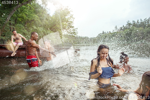 Image of Enjoying river party with friends. Group of beautiful happy young people at the river together