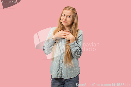 Image of The happy business woman standing and smiling against pink background.