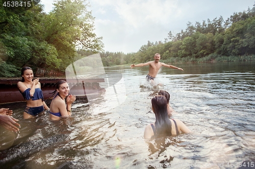 Image of Enjoying river party with friends. Group of beautiful happy young people at the river together