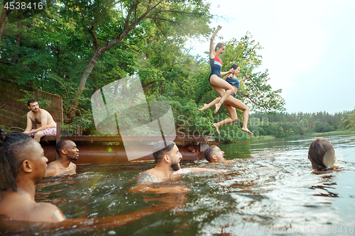 Image of Enjoying river party with friends. Group of beautiful happy young people at the river together