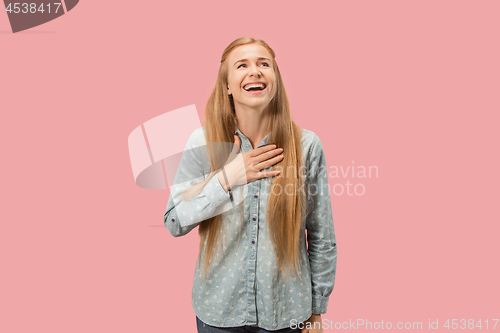 Image of The happy business woman standing and smiling against pink background.