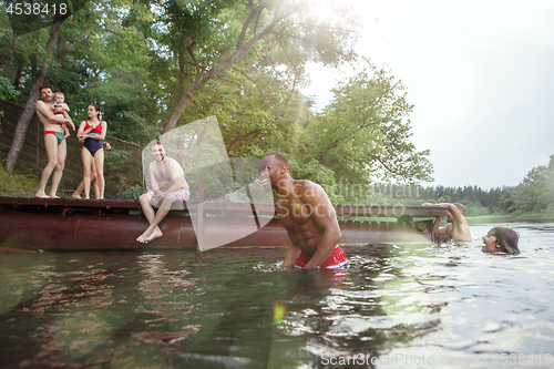 Image of Enjoying river party with friends. Group of beautiful happy young people at the river together