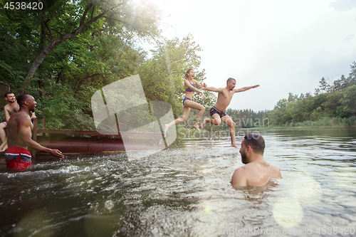 Image of Enjoying river party with friends. Group of beautiful happy young people at the river together