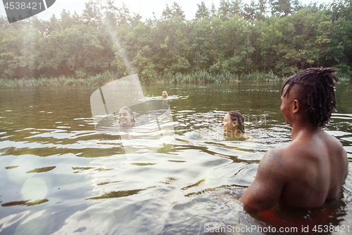 Image of Enjoying river party with friends. Group of beautiful happy young people at the river together