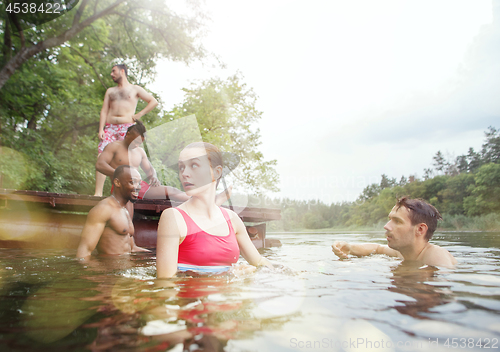 Image of Enjoying river party with friends. Group of beautiful happy young people at the river together