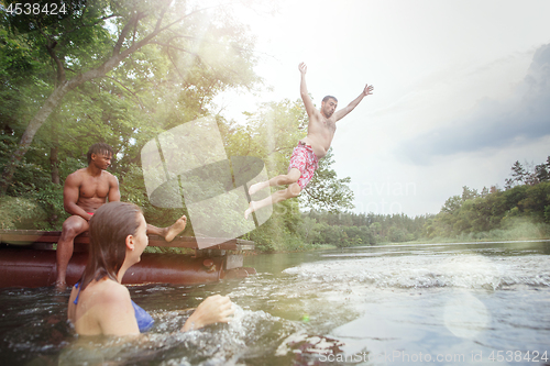 Image of Enjoying river party with friends. Group of beautiful happy young people at the river together