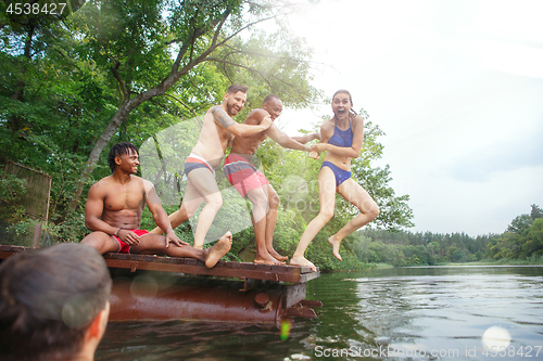 Image of Enjoying river party with friends. Group of beautiful happy young people at the river together