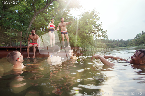 Image of Enjoying river party with friends. Group of beautiful happy young people at the river together