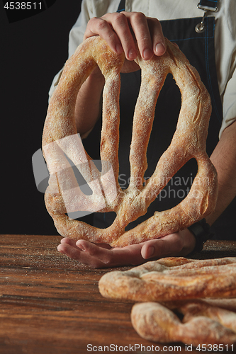 Image of Hands men holding fougas bread