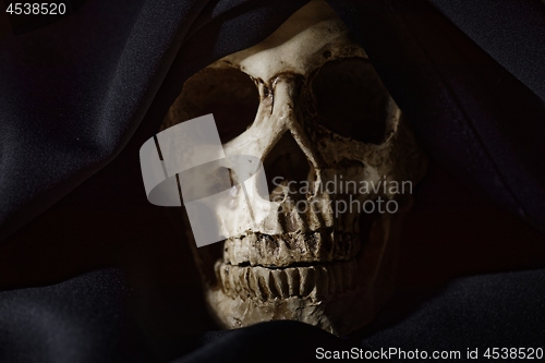 Image of Closeup photo an old skull covered in black robe