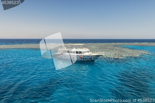 Image of Luxury yacht docking near coral reef