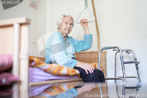 Image of Elderly 96 years old woman sitting on medical bed in hospic.