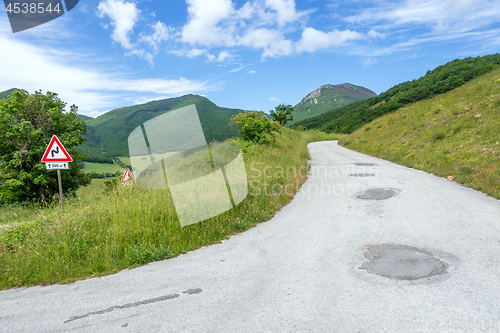 Image of some street signs on a steep road