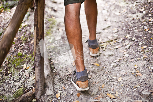 Image of Man's legs on park or forest footpath with handrail closeup. 