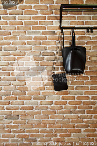 Image of Modern hallway loft interior and black leather bags on hanger ag