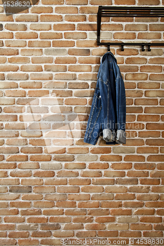 Image of Modern hallway loft interior with denim coat on hanger against b