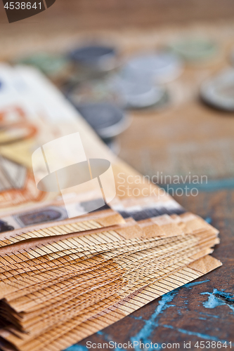 Image of Pile of fifty euro banknotes and coins.