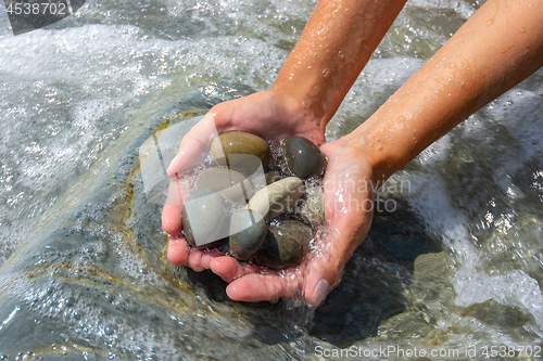 Image of Wave covered palms with large sea pebbles