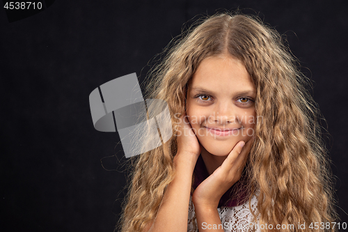 Image of Closeup portrait of a cheerful ten year old girl on black background