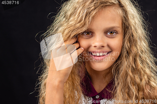 Image of Portrait of a ten year old girl smiling widely with curly blond hair