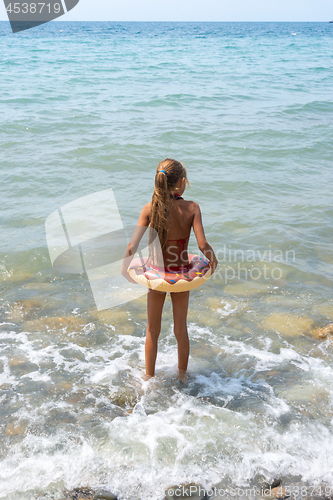 Image of Girl with a circle goes swimming in the sea