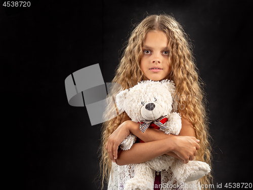 Image of Portrait of a teenage girl who hugs an old soft toy bear