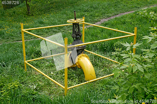 Image of Gas valve outside among green grass