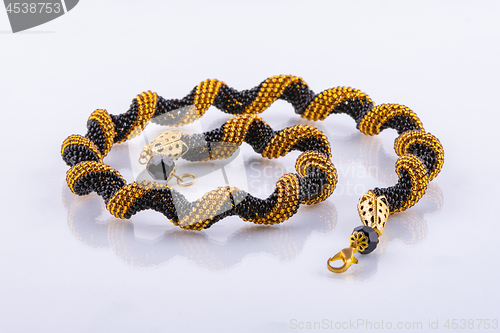 Image of Handmade small bead bracelet in black and gold beads