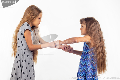 Image of Two girls fight, grabbing each other\'s fists