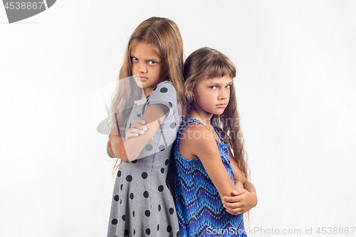 Image of Two offended girls stand with their backs to each other