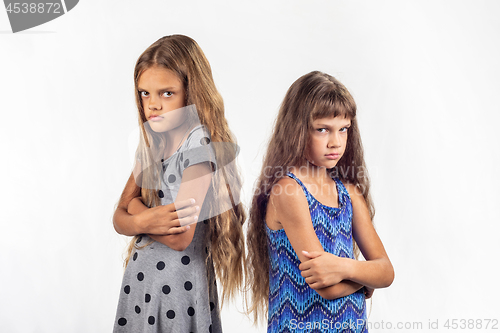 Image of Two offended girls stand with their backs to each other