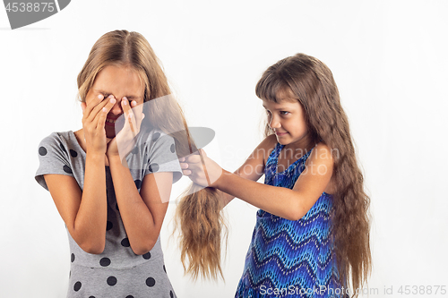 Image of Girl pulls another girl by the hair