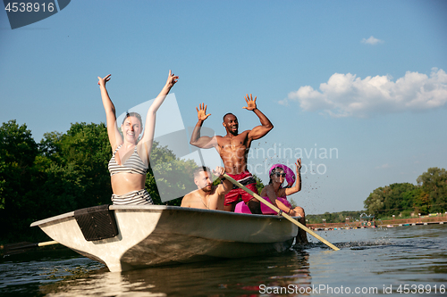 Image of Happy group of friends having fun, laughting and swimming in river