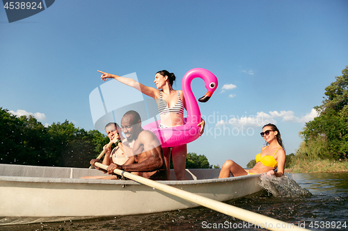 Image of Happy group of friends having fun, laughting and swimming in river