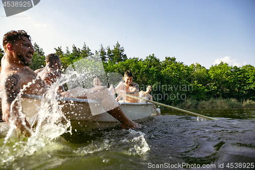 Image of Happy group of friends having fun, laughting and swimming in river