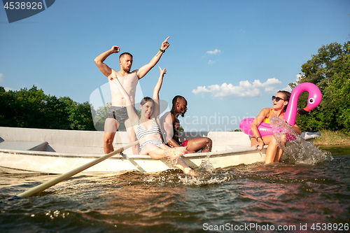 Image of Happy group of friends having fun, laughting and swimming in river