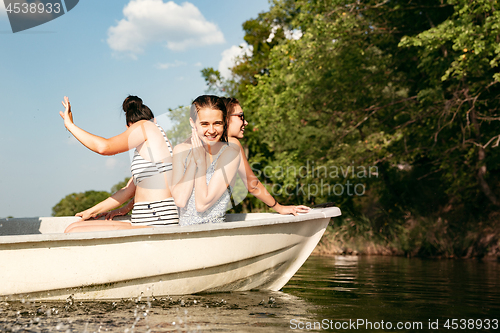 Image of Happy group of friends having fun, laughting and swimming in river