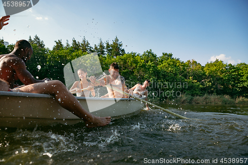 Image of Happy group of friends having fun, laughting and swimming in river