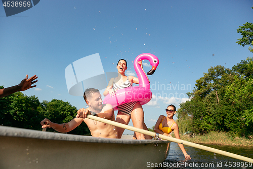 Image of Happy group of friends having fun, laughting and swimming in river