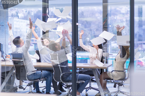 Image of startup Group of young business people throwing documents