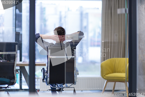 Image of young businessman relaxing at the desk