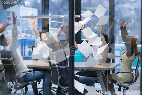 Image of startup Group of young business people throwing documents