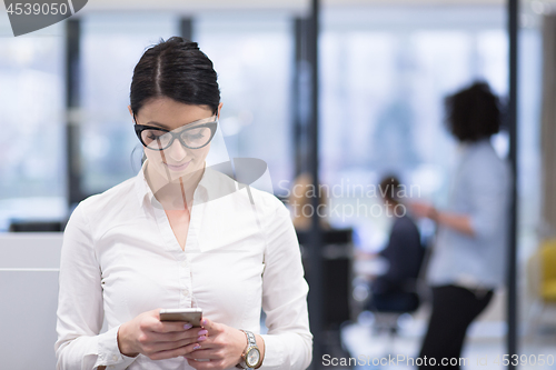 Image of Elegant Woman Using Mobile Phone in startup office building