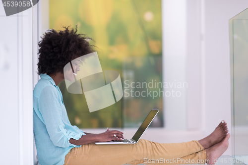 Image of black women using laptop computer on the floor