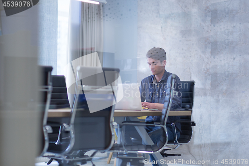 Image of businessman working using a laptop in startup office