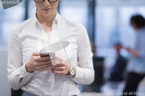 Image of Elegant Woman Using Mobile Phone in startup office building