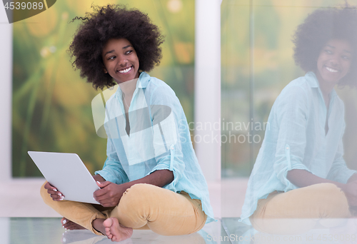 Image of black women using laptop computer on the floor