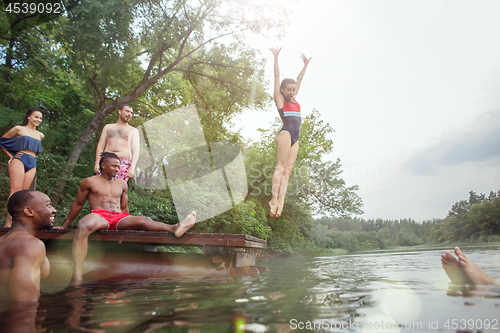 Image of Enjoying river party with friends. Group of beautiful happy young people at the river together