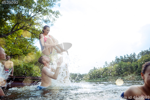 Image of Enjoying river party with friends. Group of beautiful happy young people at the river together